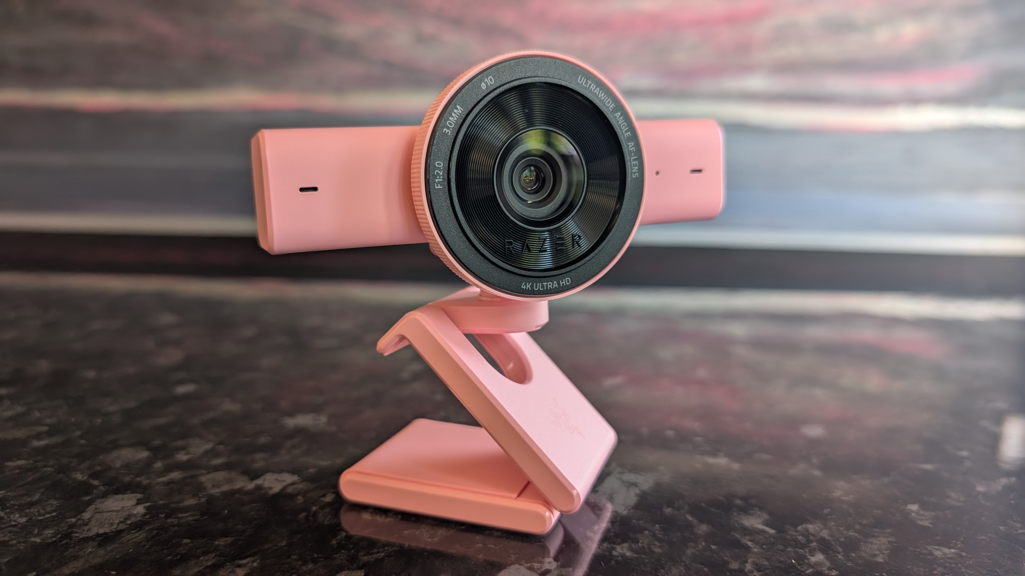 The Razer Kiyo V2 webcam pictured on a dark marble worksurface.