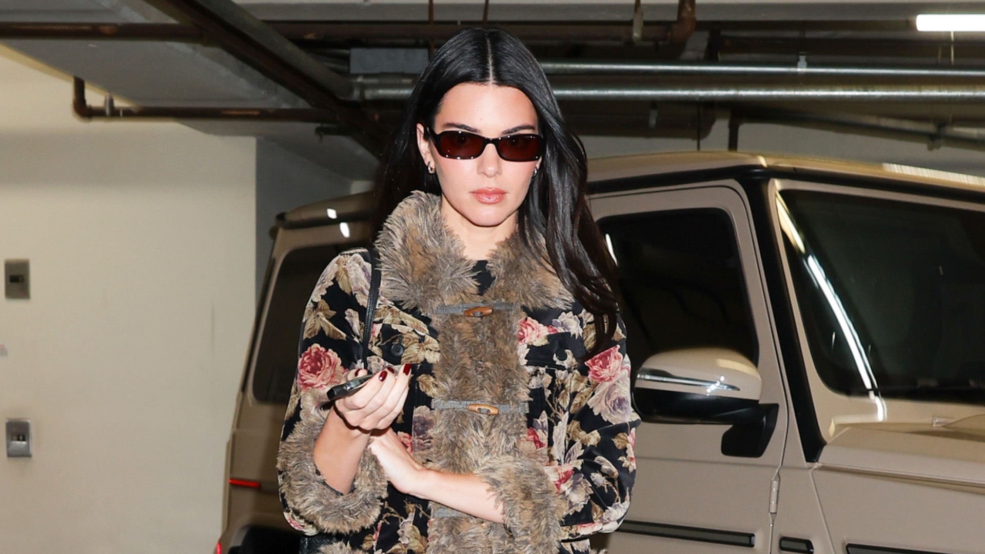Kendall Jenner wearing a fur-trimmed jacket, dark-wash Khaite jeans, and black The Row ballet flats