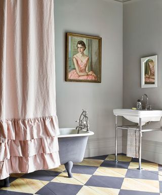 A neutrally decorated bathroom with pink curtain and painting on the wall