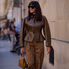 a stylish woman wearing a peplum jacket during fashion week