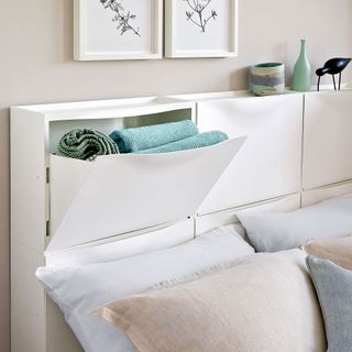 close up of a modern bed with a headbaord made out of the Ikea shoe rack cupboord