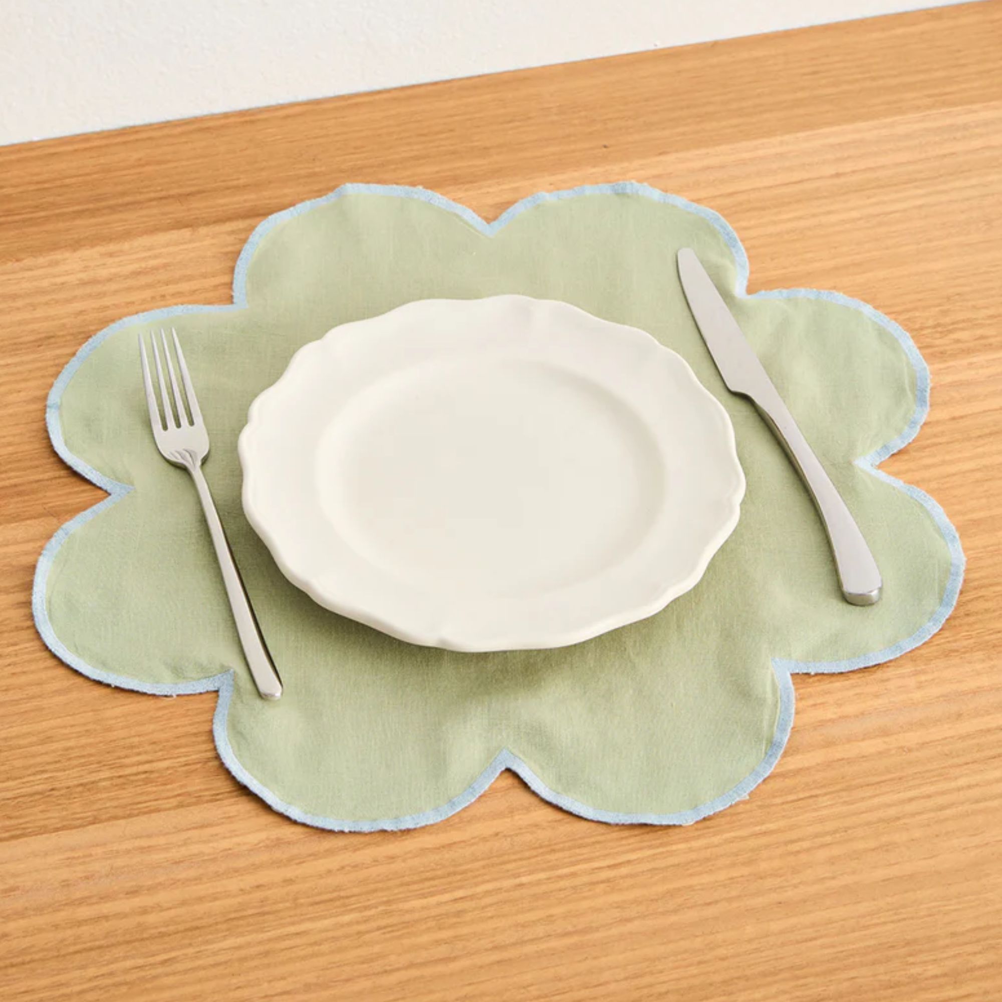 Pale green flower-shaped placemat with pale blue trim