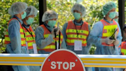 Masked health workers at the quarantine zone