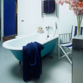 bathroom with vinyl floor and bathtub and blue towel