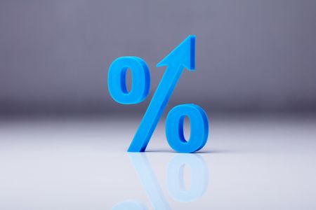Close-up of A blue percentage symbol on a reflective gray background