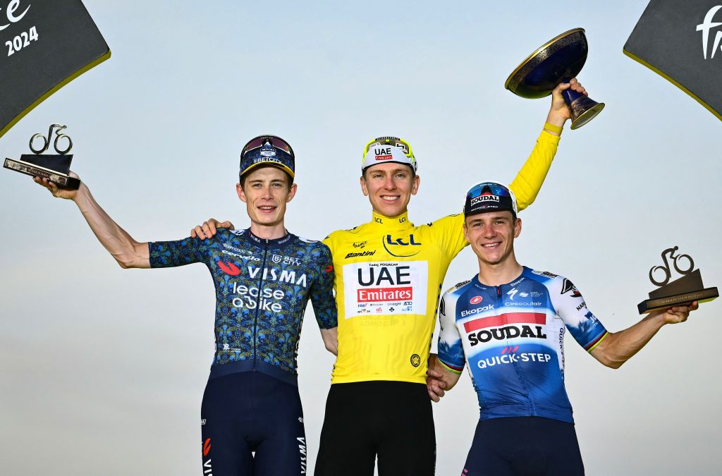 Overall winner UAE Team Emirates team&#039;s Slovenian rider Tadej Pogacar (C) celebrates on the podium, flanked by second-placed Team Visma - Lease a Bike team&#039;s Danish rider Jonas Vingegaard (L) and third-placed Soudal Quick-Step team&#039;s Belgian rider Remco Evenepoel (R) after the 21st and final stage of the 111th edition of the Tour de France