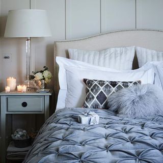 Bed with grey throw and candles