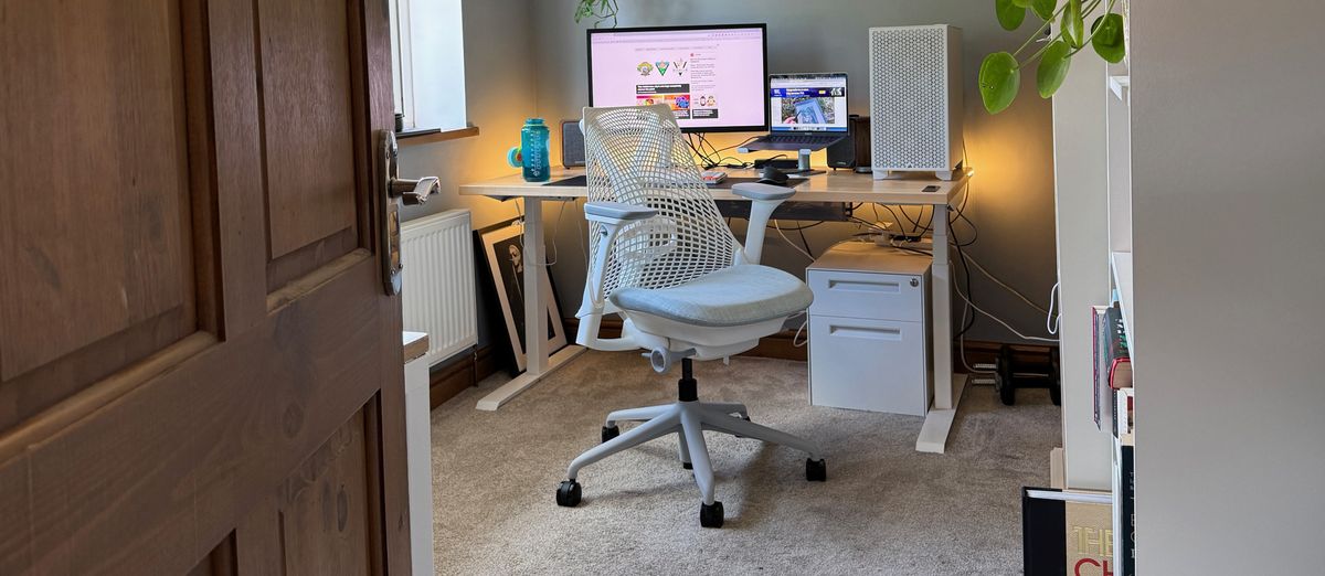 A white Sayl chair next to a standing desk.