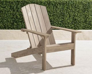 A teak wood Adirondack chair on a patio