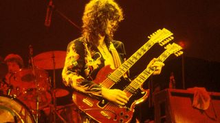 Photo of Jimmy PAGE and LED ZEPPELIN, Jimmy Page performing live onstage. Full length, holding guitar up, wearing suit with dragons printed up leg, playing Gibson EDS-1275 twin-neck/double-neck guitar.