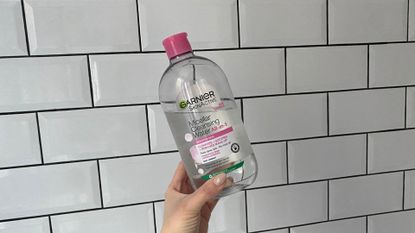 Garnier Micellar Water - lucy abbersteen holding a bottle of the micellar water up against white tiles