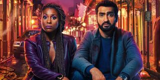 The Lovebirds Issa Rae and Kumail Nanjiani sitting in front of a chaotic street, straight faced