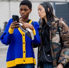 MILAN, ITALY - FEBRUARY 23: Models looking on phone outside Prada during the Milan Fashion Week Womenswear Fall/Winter 2023/2024 on February 23, 2023 in Milan, Italy. (Photo by Christian Vierig/Getty Images)
