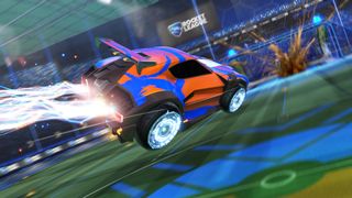 Rocket League, voiture bleue avec des autocollants orange qui accelere sur le terrain.
