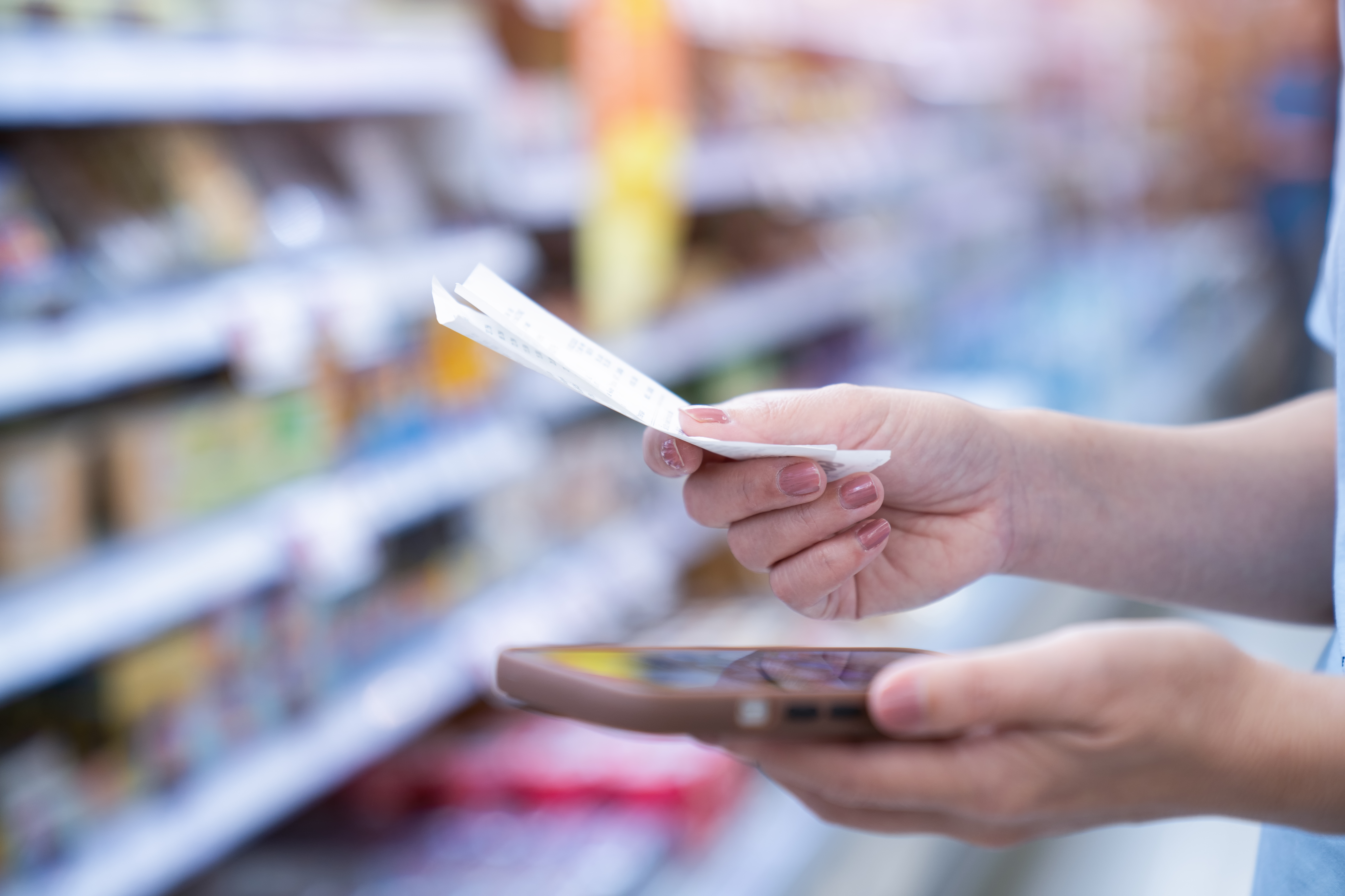 Woman holding receipt in supermarket
