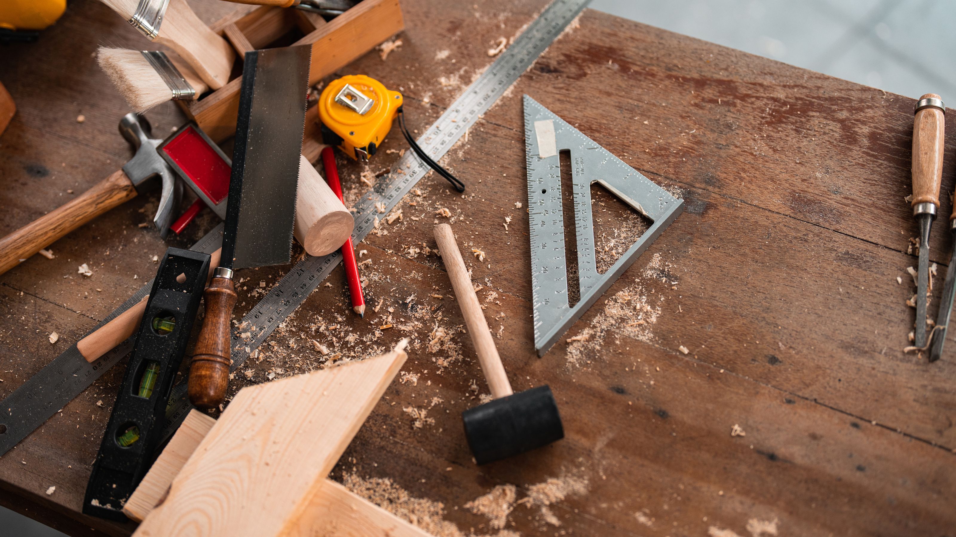 Tools, including set square, mallet, and tape measure, on a workbench