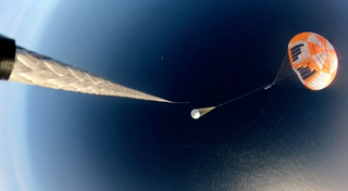 This screenshot from a Rocket Lab video shows the company catching a dummy booster using a helicopter during a recent test.