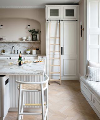 White kitchen with island and wooden flooring
