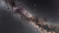 The northern summer Milky Way through the area of the Summer Triangle, showing the change in colour as the Milky Way heads south toward the dustier regions around the galactic core Deneb in Cygnus is at top, Vega in Lyra is to the upper right, and Altair in Aquila is at bottom The dark lanes of the Cygnus Rift show up well, beginning in Cygnus and splitting the Milky Way in two on south 