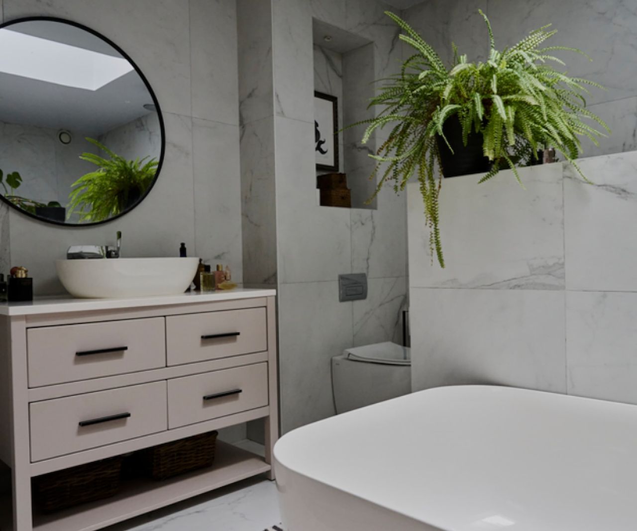 A white bathroom with porcelain tiles and a white bath and sink with a wall mirror