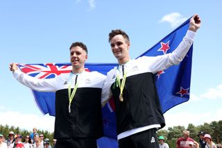 Ben Oliver and Sam Gaze of New Zealand celebrate their silver and gold medals in the Commonwealth Games cross country event