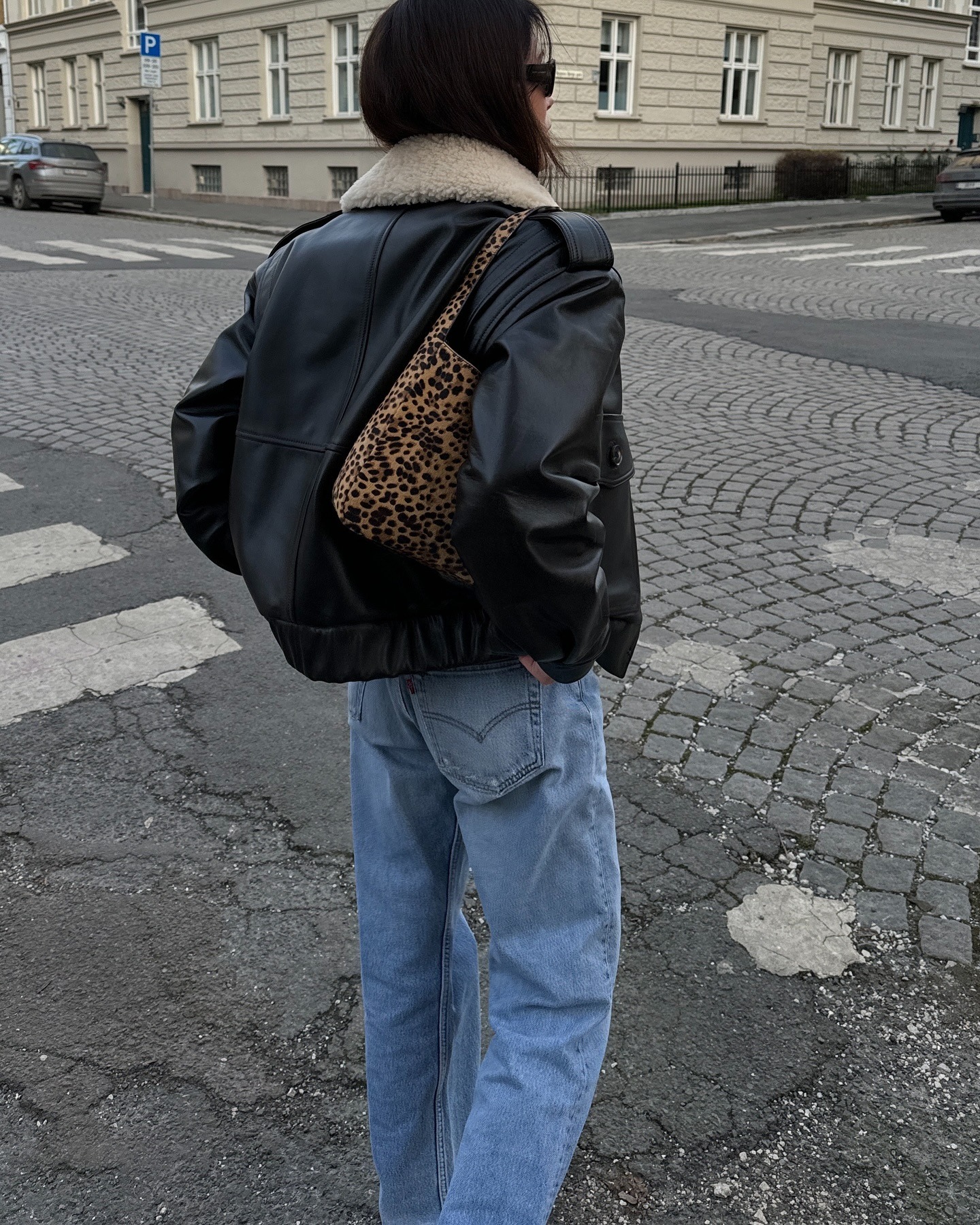 Influencer @annabelrosendahl wears blue jeans with a leather sheepskin jacket and a leopard print bag.