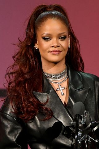 Rihanna is pictured with red 'burgundy' hair whilst speaking onstage at the 2019 BET Awards on June 23, 2019 in Los Angeles, California.
