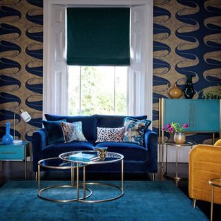 Blue living room with blue velvet sofa and gold accents