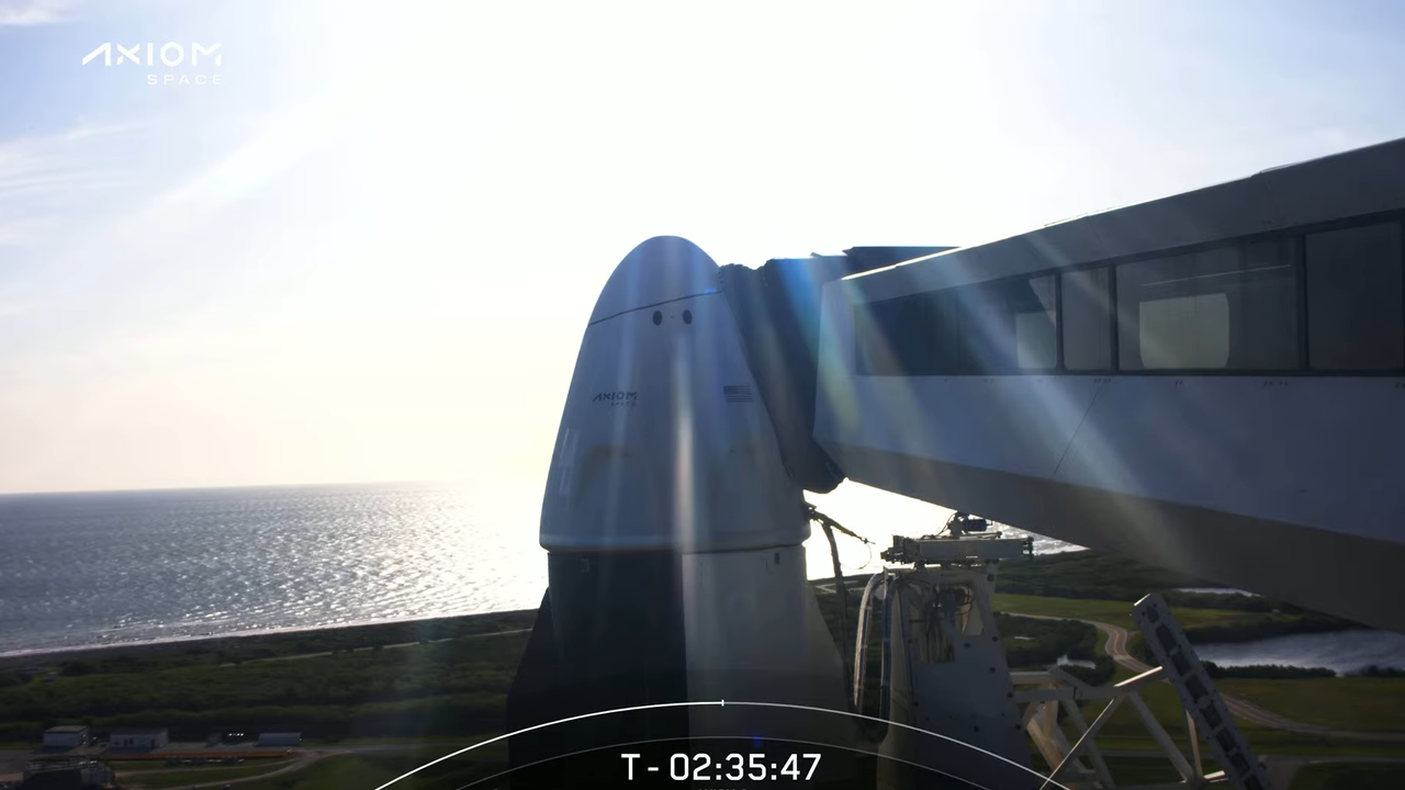 A view of the Endeavour capsule on the launch pad with the waters off Kennedy Space Center in the background.