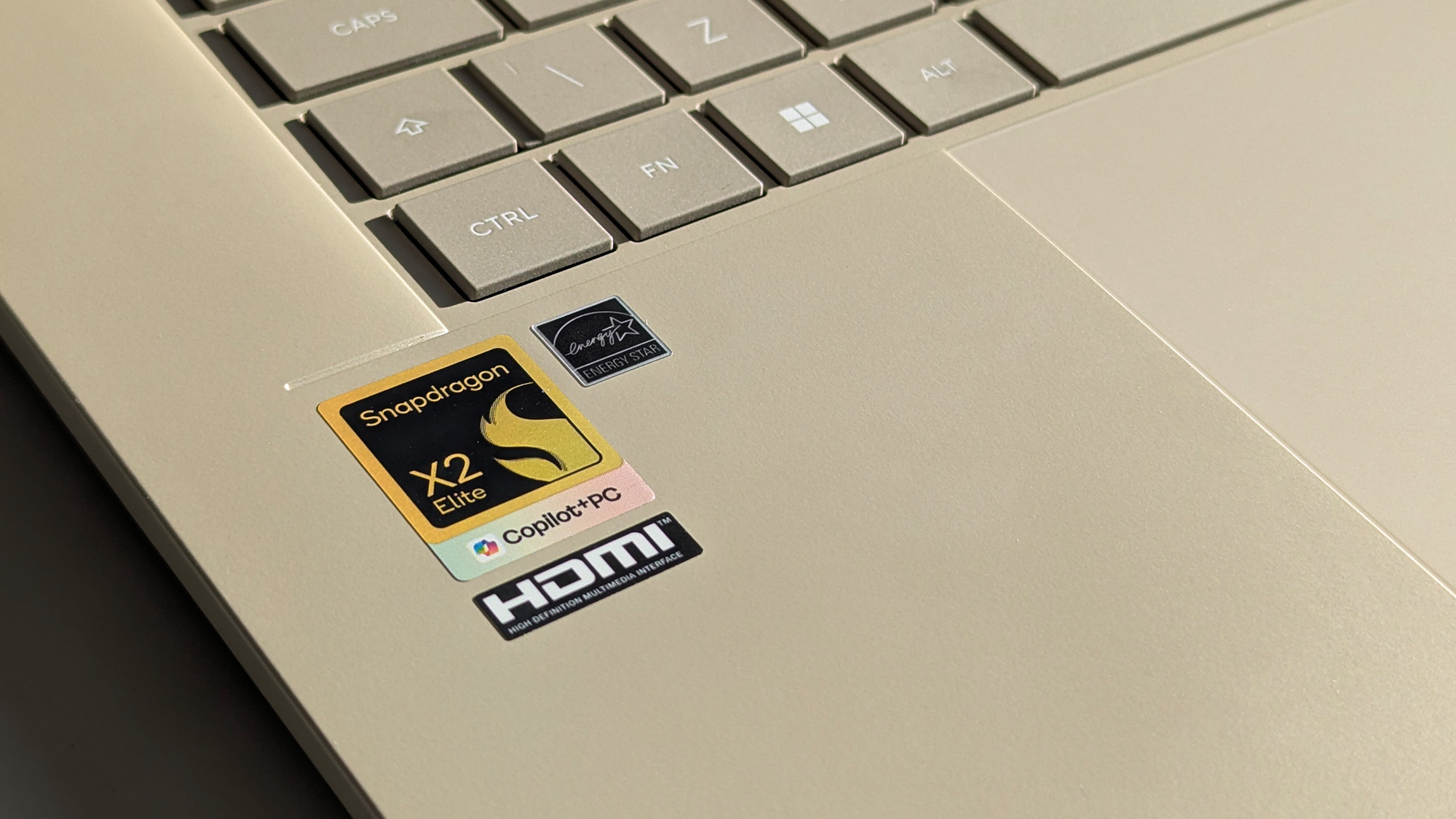 Snapdragon X2 Elite sticker with Copilot+ PC branding on ASUS Zenbook A16 laptop in Zabriskie Beige