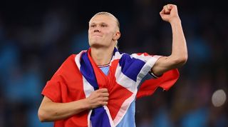 Erling Haaland, draped in a Norway flag, celebrates Manchester City's victory over Real Madrid in the Champions League in May 2023.