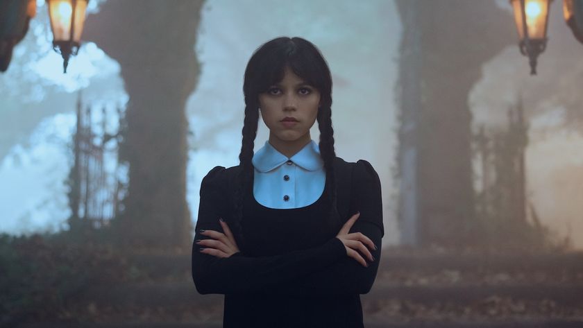 Wednesday with arms crossed outside in cemetery in Wednesday Season 2