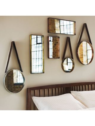 decorating a rented home: brass mirrors above bed