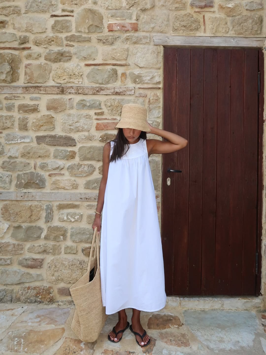 Woman in white dress and raffia hat
