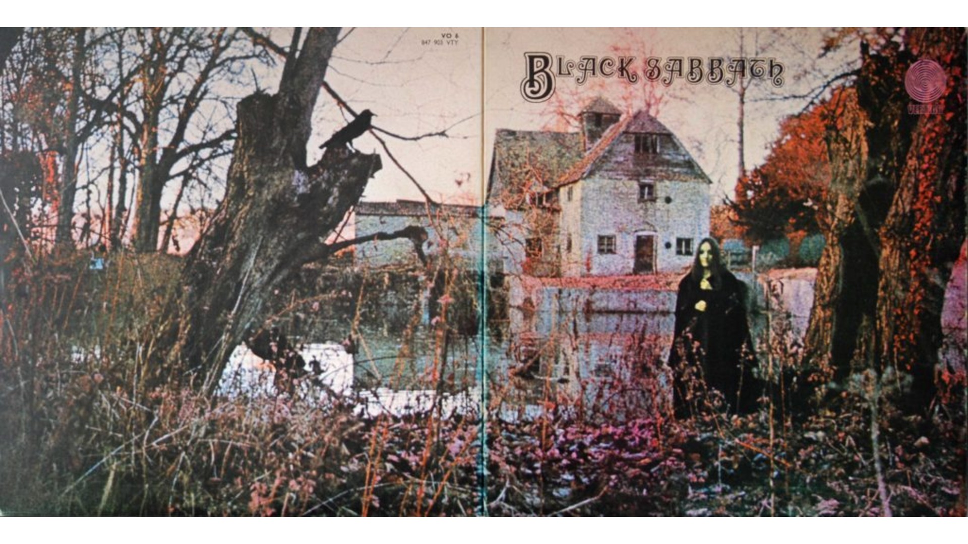 The gatefold album cover for Black Sabbath's debut album features a moody, somewhat desaturated landscape. On the left panel, a large, gnarled tree with a crow perched on a branch dominates the foreground. In the background, there are hints of buildings. The right panel shows a dark, shadowy figure of a woman in a black cloak standing in front of an old, stone building, possibly a mill or house, next to a body of water that reflects the building.
