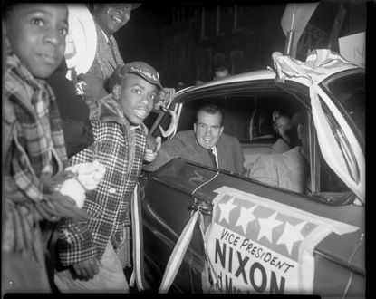 Vice President Richard Nixon and Pat Nixon greeting the crowd from their car in 1960.