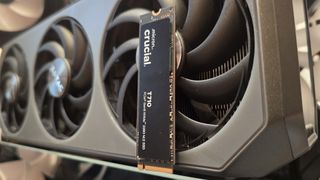 A Crucial T710 SSD on some fans ready to be installed inside a gaming PC.