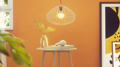 Yellow wall with a smart light bulb pendant shown