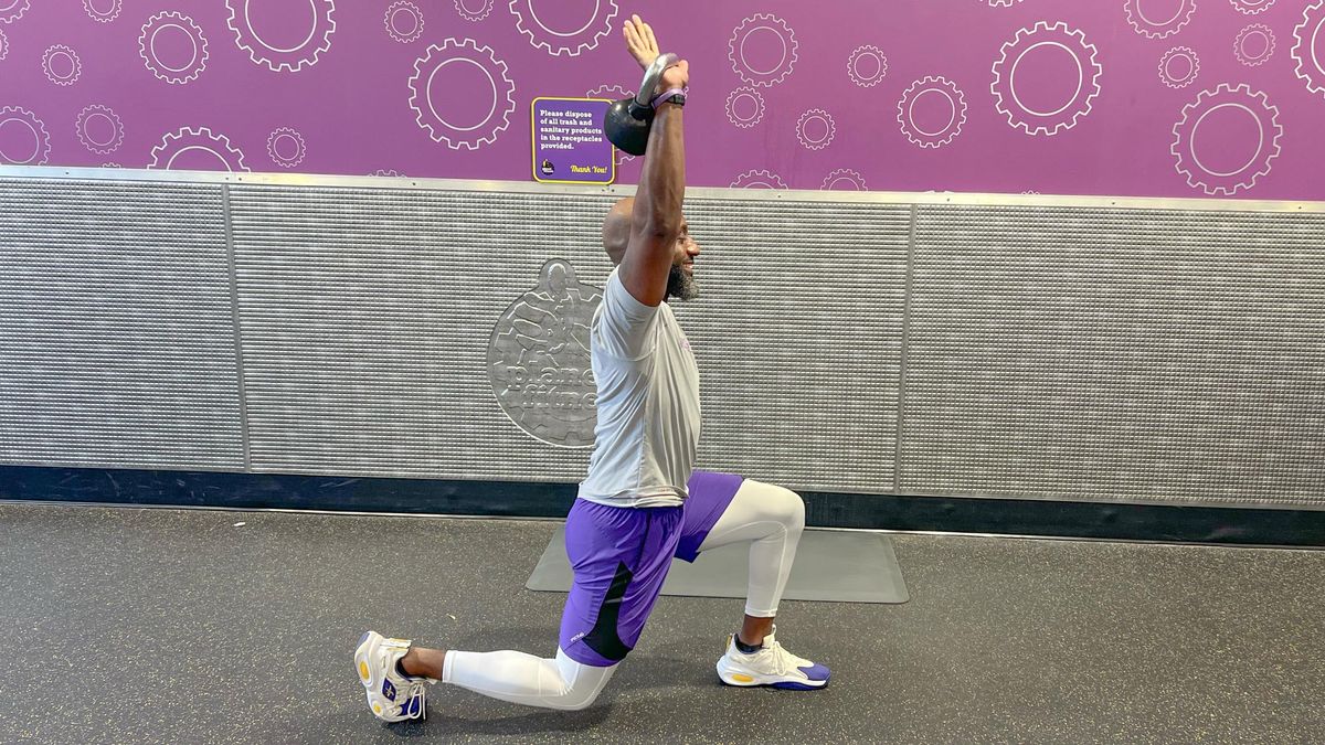 Teddy Savage completing an alternating reverse lunge to overhead shoulder press
