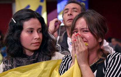 People in Colombia react after hearing the referendum vote outcome.