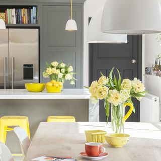 kitchen and dinning area grey door and flower vase on table