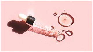 Liquid gel or serum drop with pipette on pink background