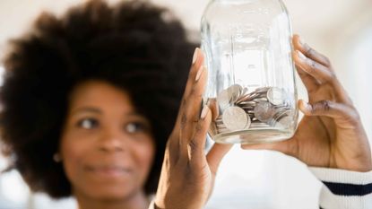 person looking at change in a jar