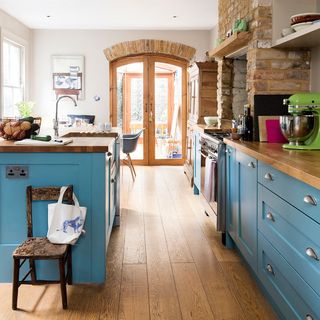 kitchen room with wooden flooring and blue cabinets with wooden worktop