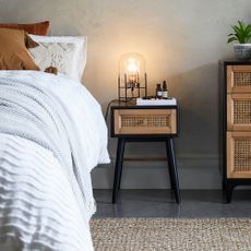 bedside table with lamp and white bedding