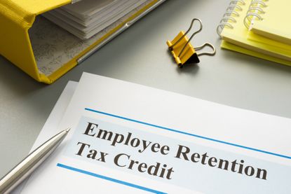 Employee retention tax credit written on form next to notebooks on a desk