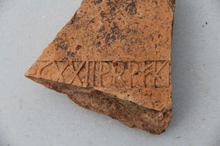A brick fragment stamped with the sign of the 22nd Roman Legion, an elite unite from the late first century.