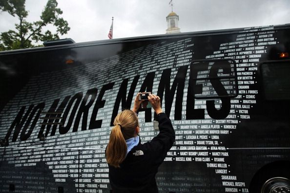 A woman takes a photograph at a Newtown 6 month remembrance event.