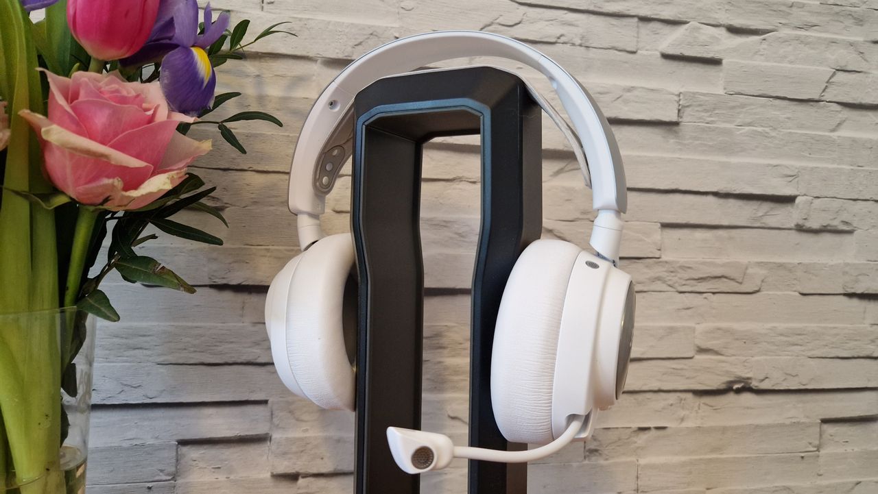 The SteelSeries Arctis Nova Pro Wireless white edition on a headset stand with a white brick background