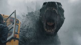 Godzilla roars at a person off-camera next to a bus in Monarch: Legacy of Monsters